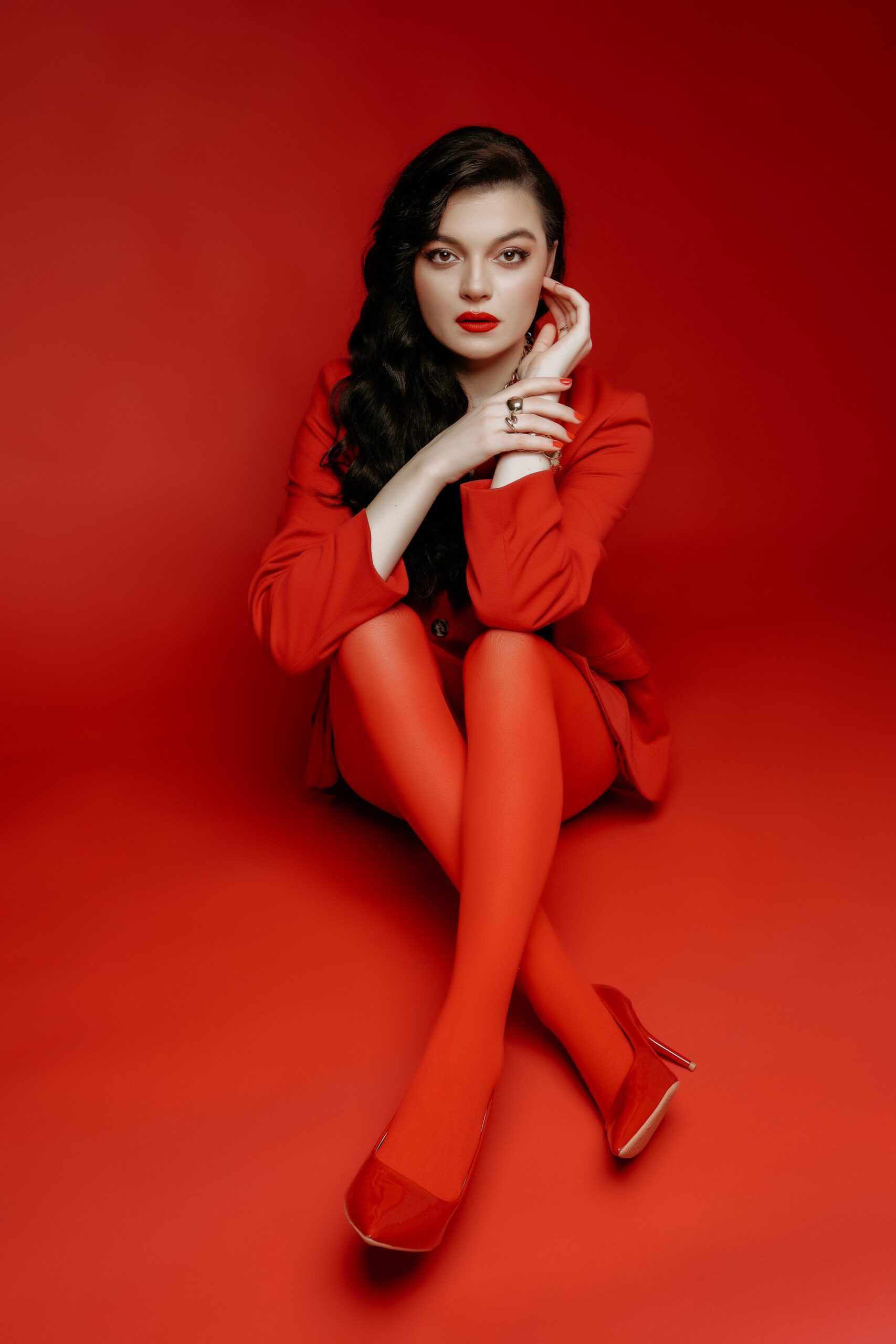 Portrait of a woman in a red outfit against a red backdrop