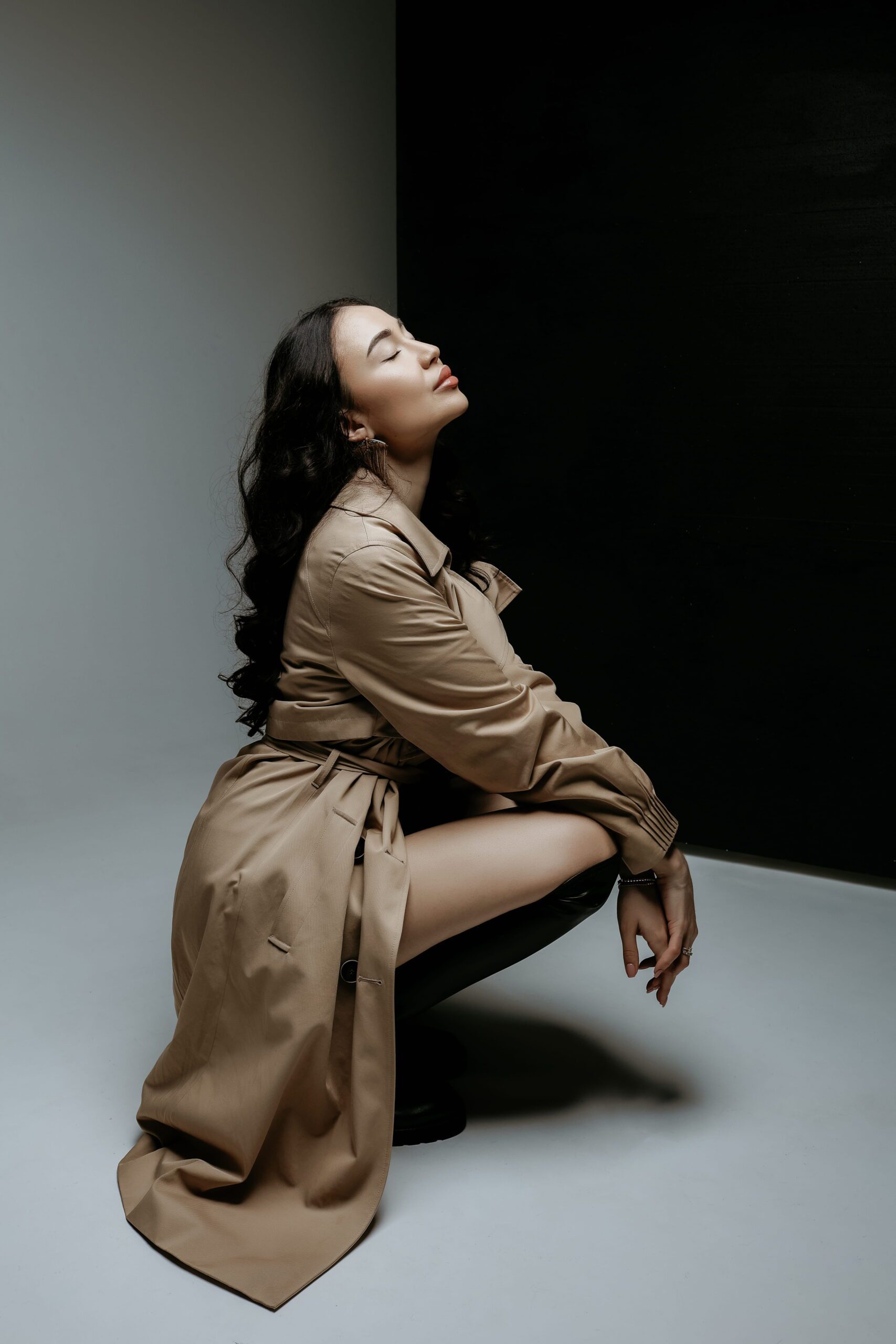 A seated woman tilting her head towards the light