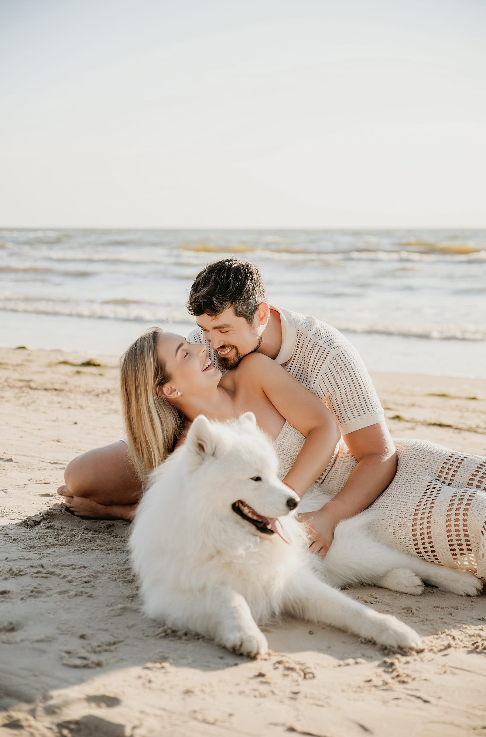 A couple sharing a quiet moment with their dog by the sea